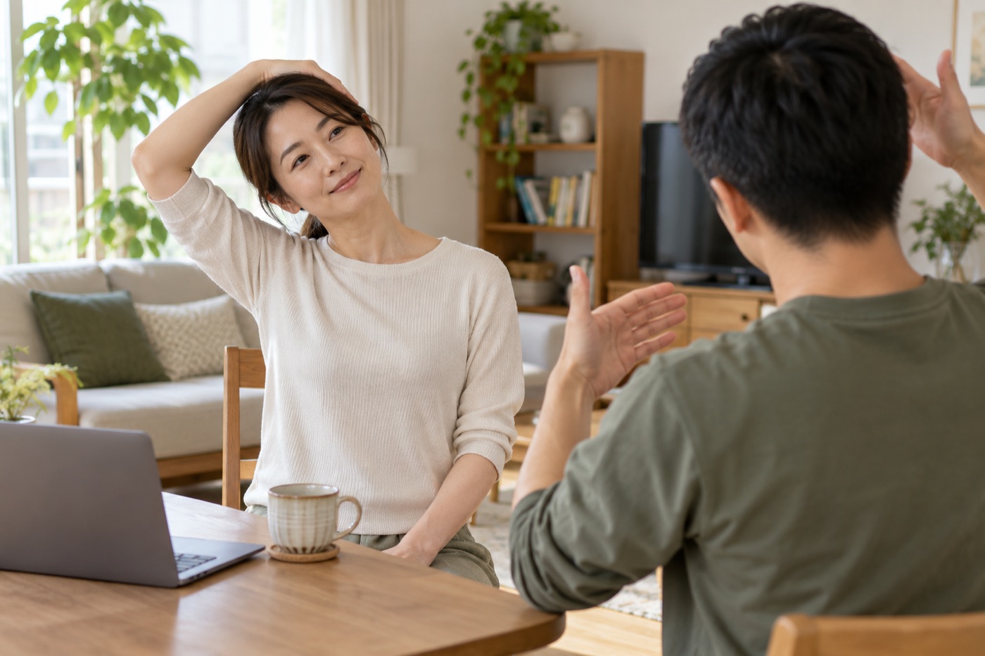 椅子に座った女性が、施術者に教わりながら首と肩のストレッチをしている様子